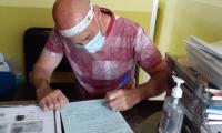 Muestra persona llenando formulario escrito en apego a normas sanitarias