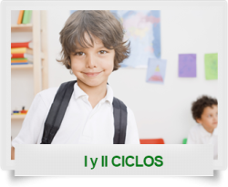 Niño con camiseta blanca en un aula, sonriendo hacia la cámara, con un bulto en su espalda.