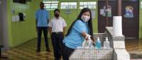 Imagen muestra a estudiantes con lavado de manos y distanciamiento