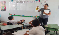Profesora explicando la señal de escuela a estudiantes