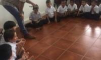 Mauricio Gutiérrez con estudiantes sentados en el peso