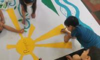 niños decorando cartel