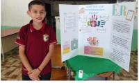 Estudiante de sexto grado expone en feria cientifíca escolar.