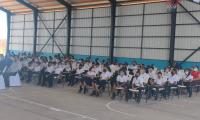 grupo de niñas y niños sentados en el acto protocolario de entrega de la escuela